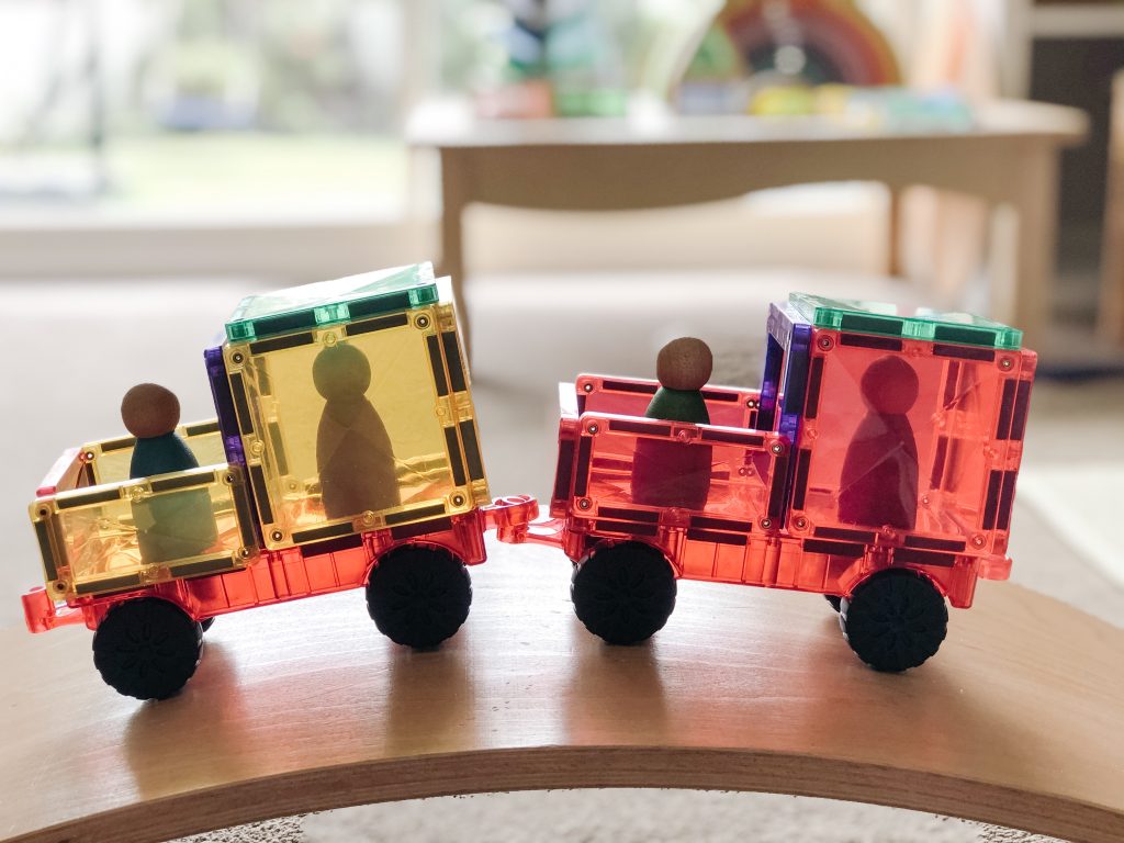Transparent toy train set on a wooden surface with blurred background