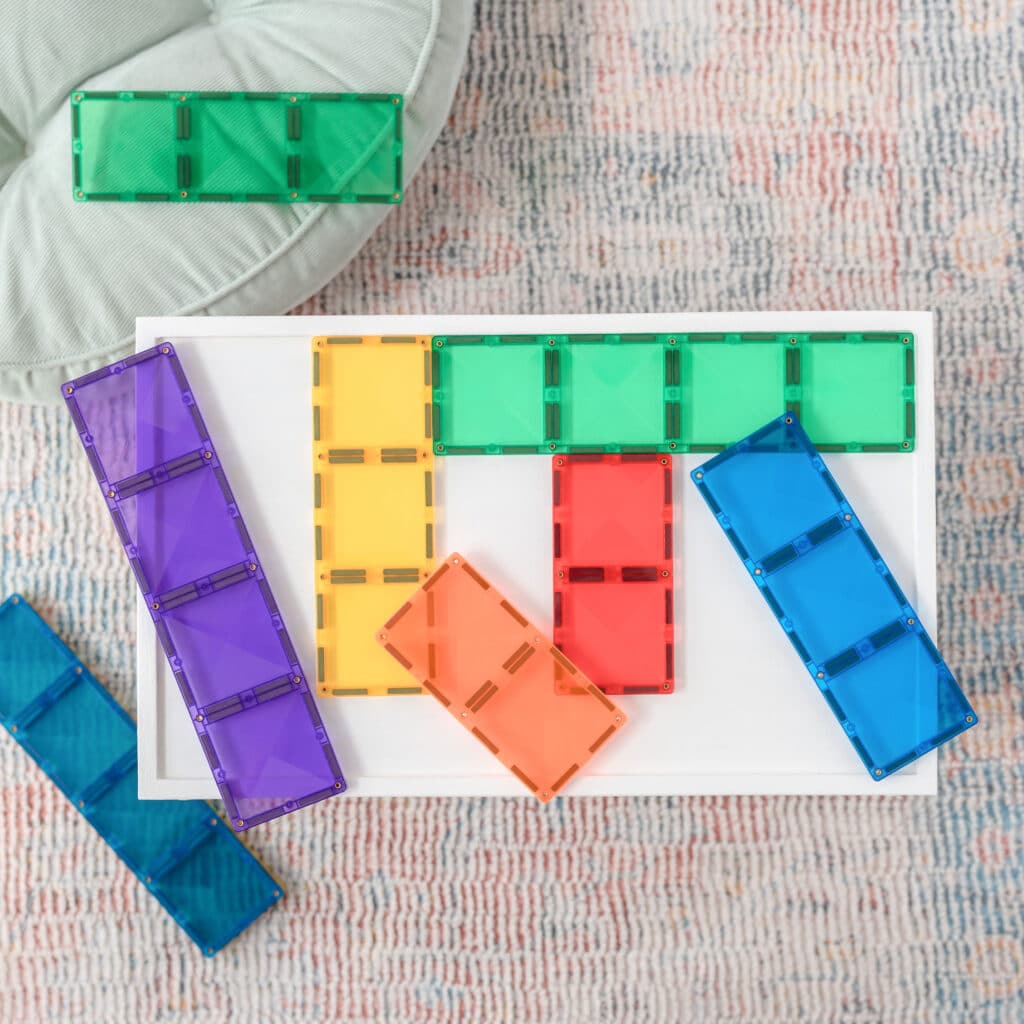 Colorful transparent building blocks on a white sheet with a textured surface background