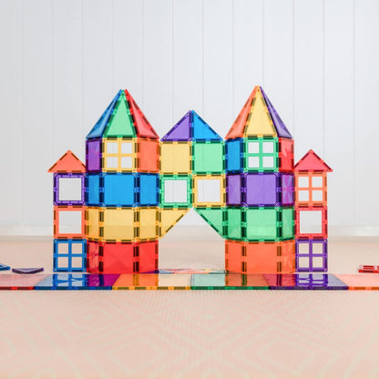 Colorful magnetic building block castle on a reflective surface with a light wooden background