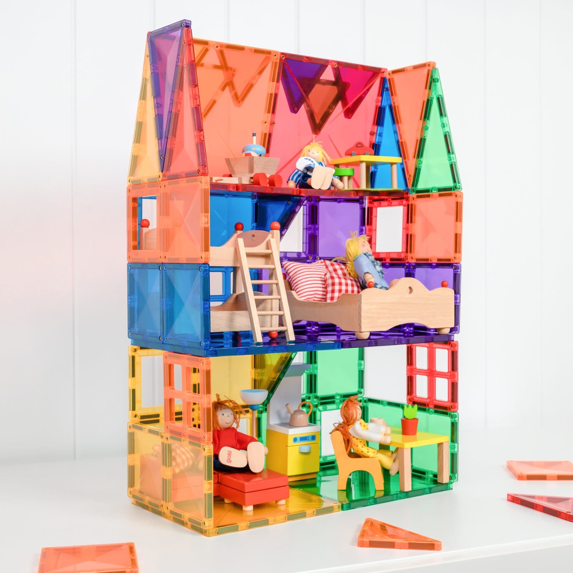 Colorful toy house with transparent walls and magnetic blocks on a white background