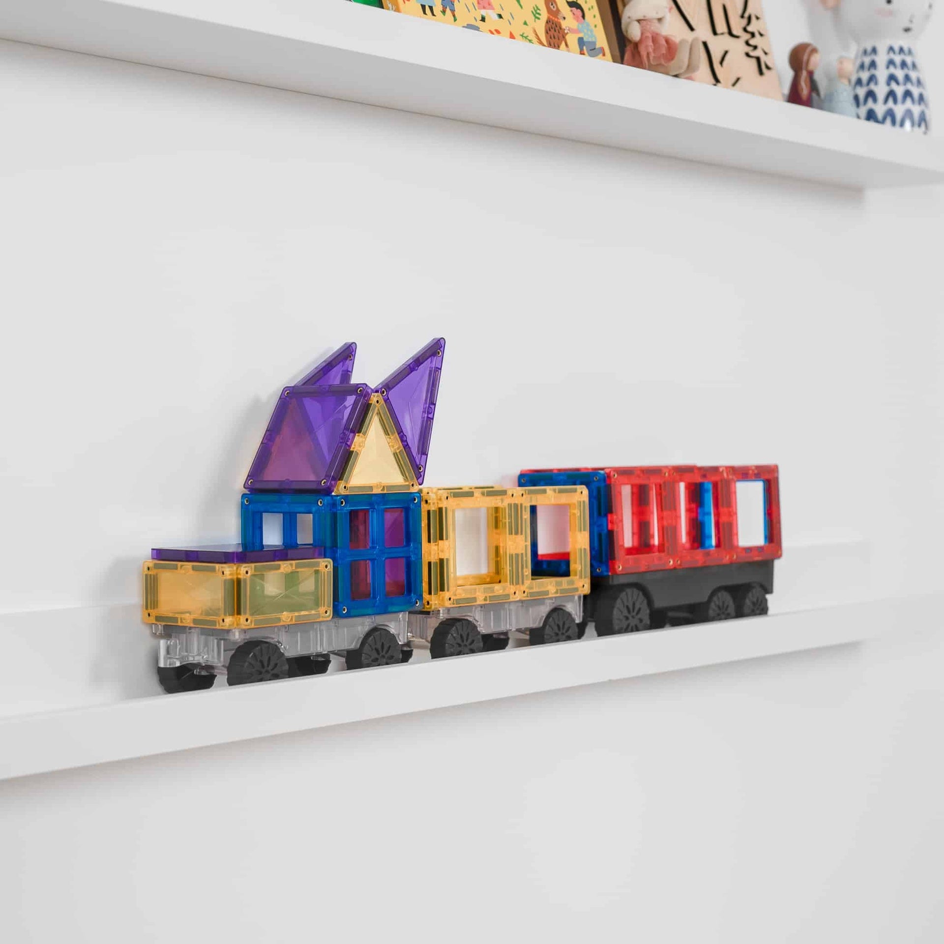 Colorful Connetix toy train set on a white shelf