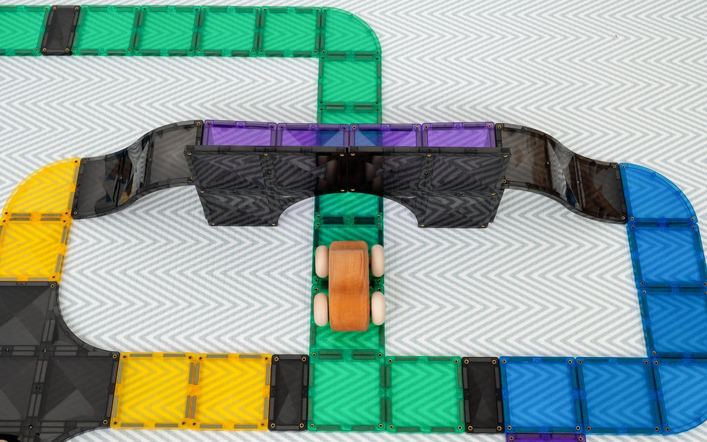 Close-up of a toy track with colorful sections on a textured surface