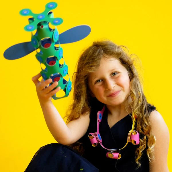 Child holding a colorful toy against a yellow background