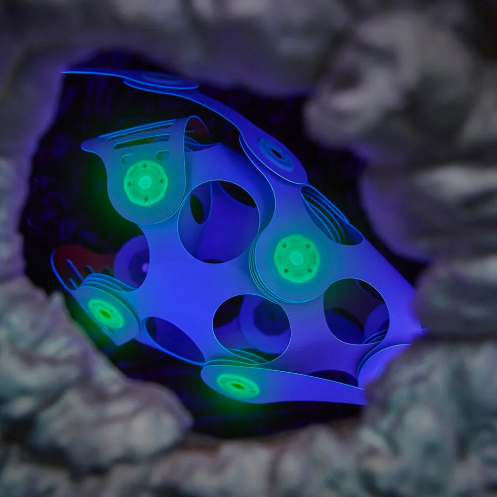 Glowing blue and green fidget spinner inside a textured dark background