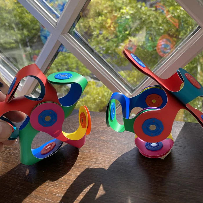 Colorful fidget spinner toy on a wooden surface with a window in the background