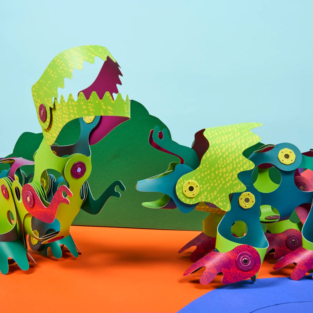 Colorful paper dragon models on a blue and orange gradient background