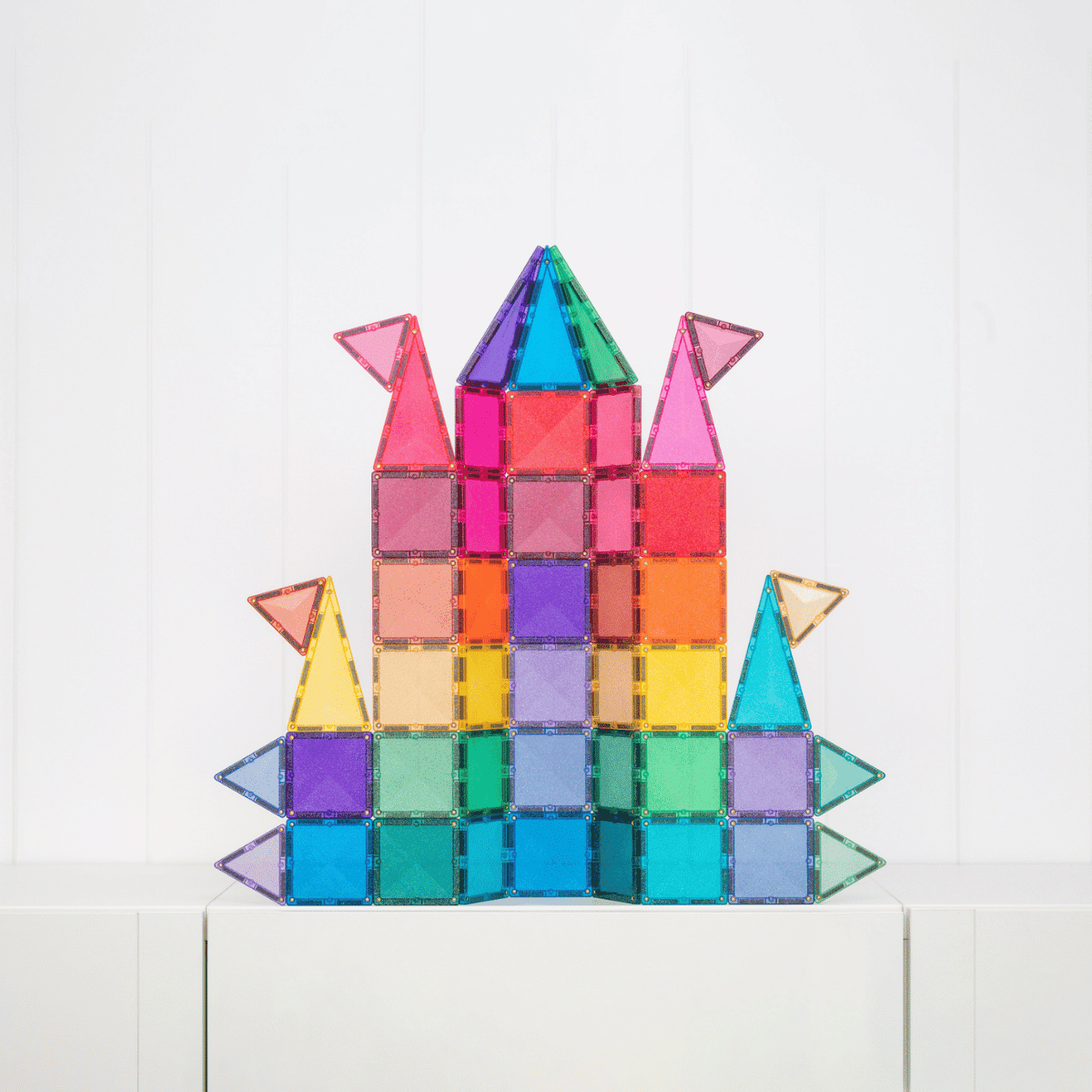 Colorful castle made of magnetic tiles on a white background