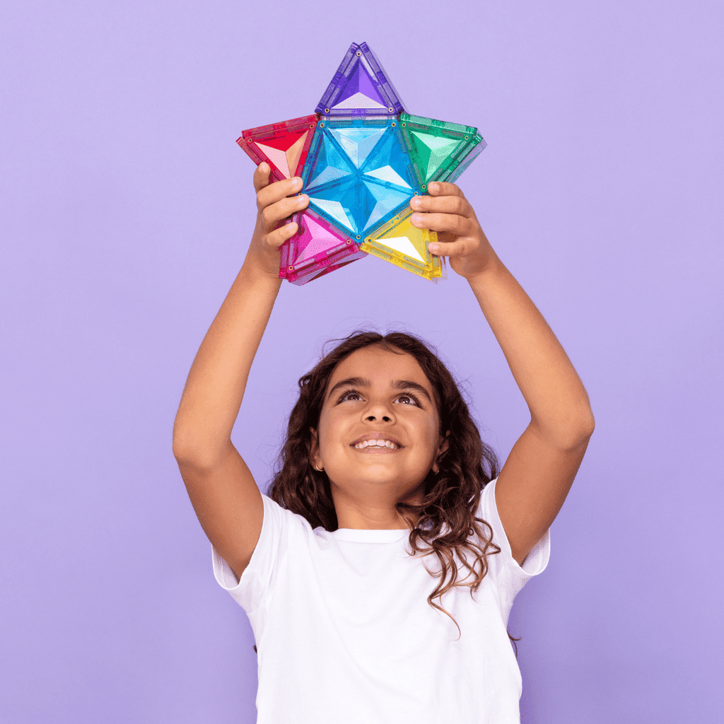Child holding a colorful geometric toy against a purple background