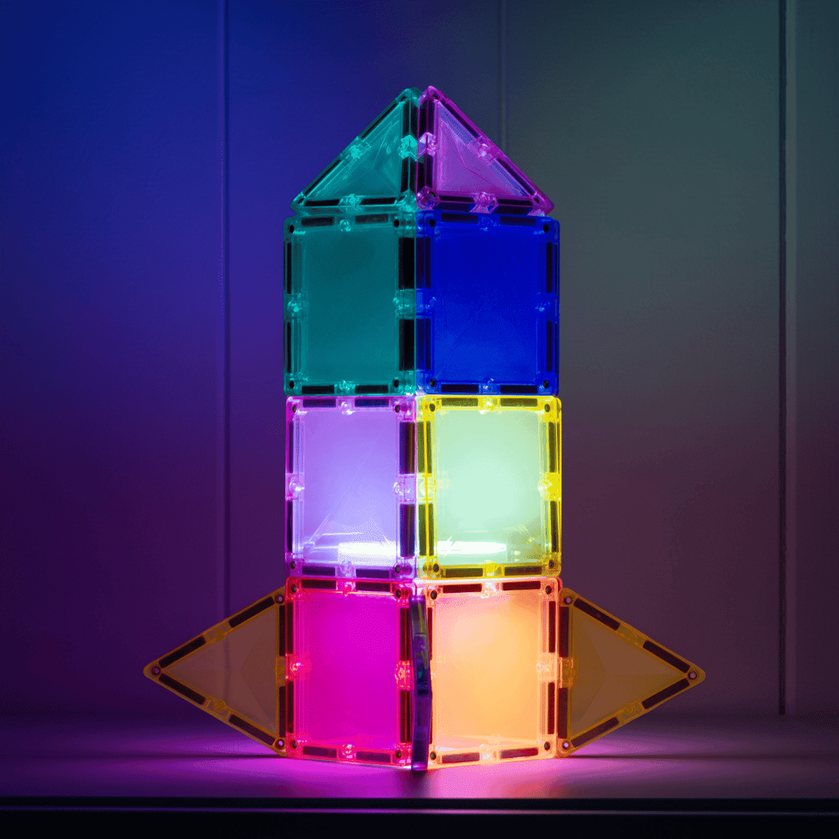 Colorful magnetic building block tower against a dark background