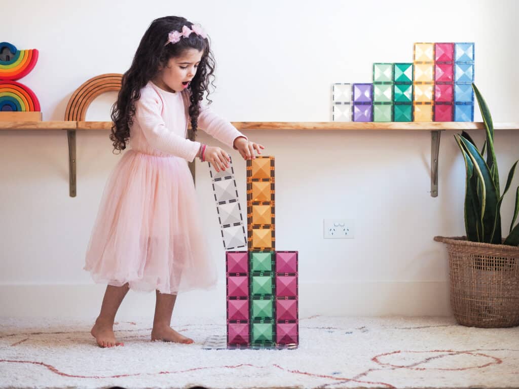 Child playing with colorful building blocks on a shelf
