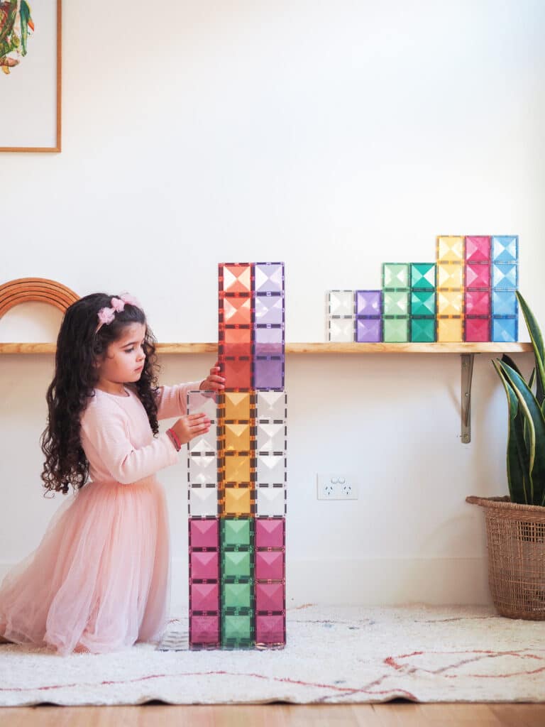 Child playing with colorful building blocks on a shelf