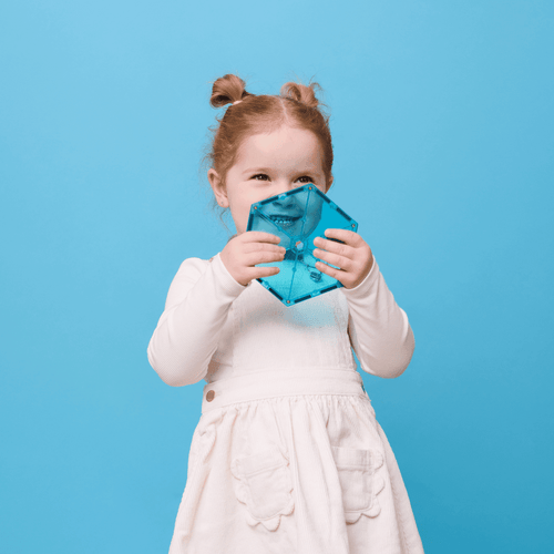 Child holding a blue tile against a blue background
