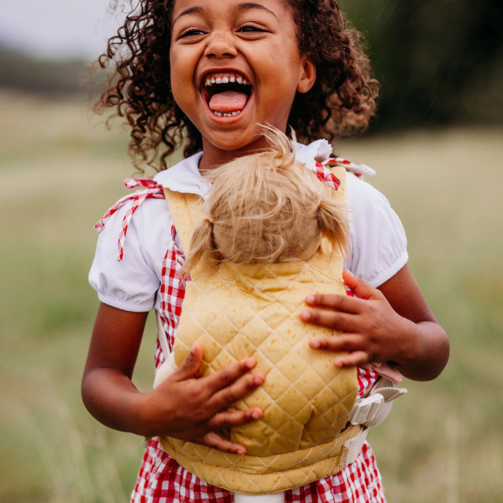 Child holding a doll in a field