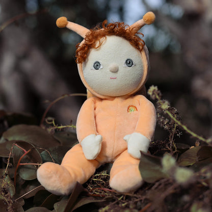 Plush toy with red hair and antlers sitting among leaves and branches