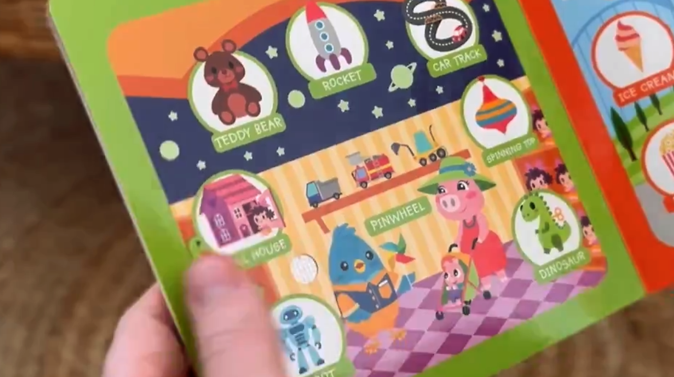 Children's educational book with colorful illustrations and text held by a hand.