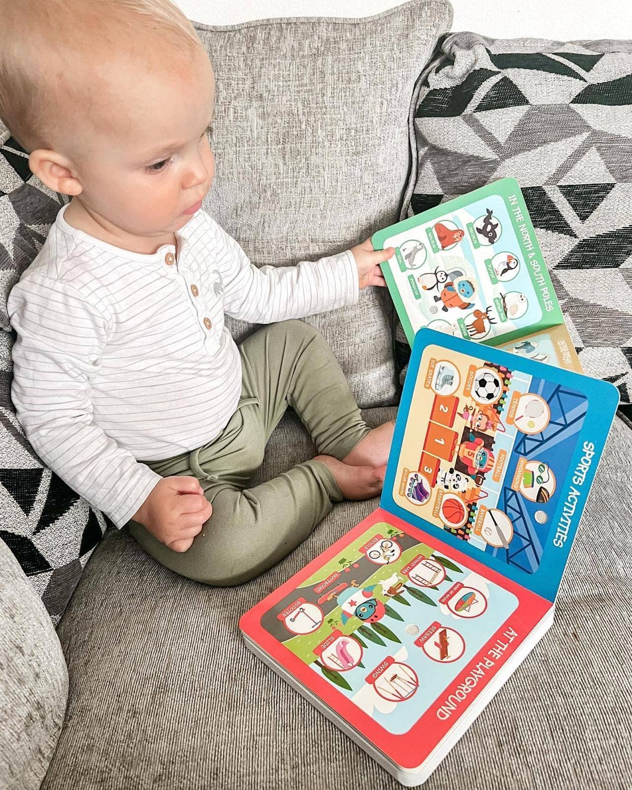 Baby sitting on a couch with three colorful books open in front of them.