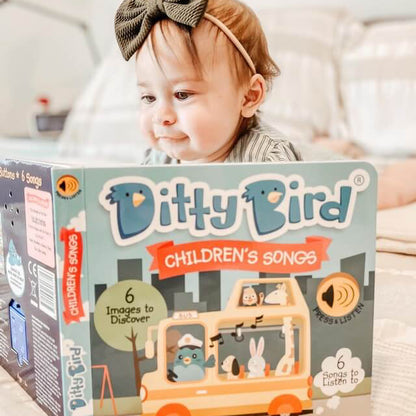 Child with a bow tie looking at a 'Ditty Bird' children's songs product box.