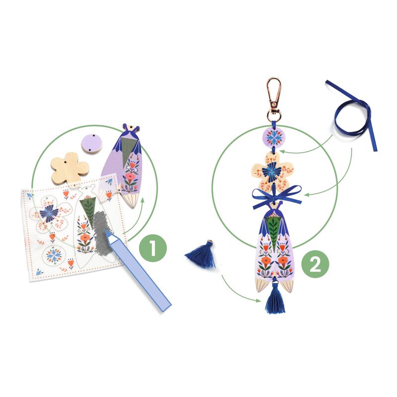 Decorative keychain with floral design and tassel, surrounded by crafting materials on a white background.