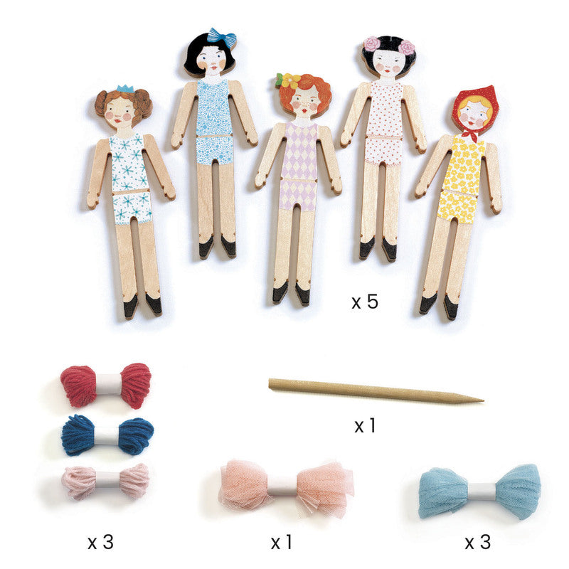 Set of wooden dolls with colorful hair accessories on a white background