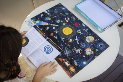 Child looking at a space-themed book on a table with a tablet next to it