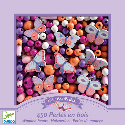 Box of wooden beads with butterfly decorations on a purple background