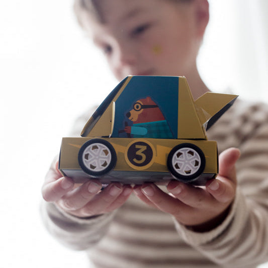 Child holding a toy car with a number 3 on it