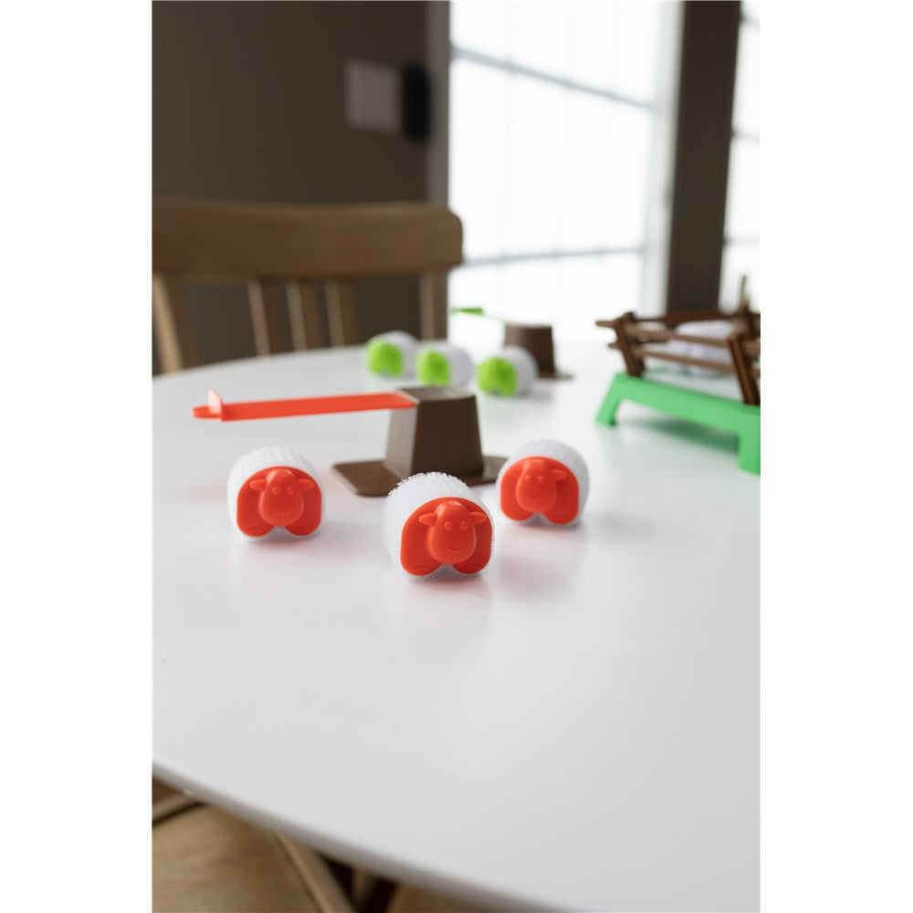 Toy sheep on a white surface with a blurred background