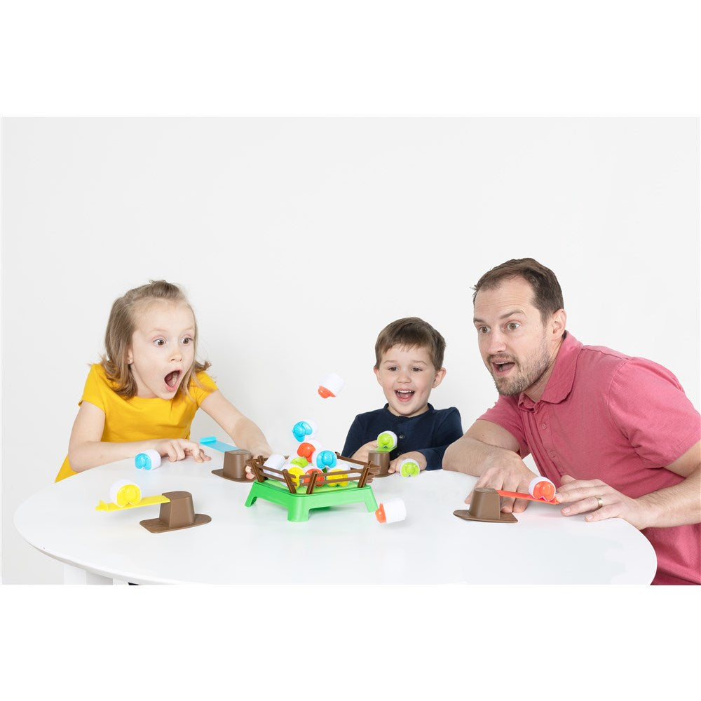 Man and two children playing with a toy on a white table