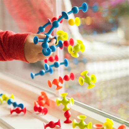 Colorful molecular model set with a child's hand interacting with it, blurred background