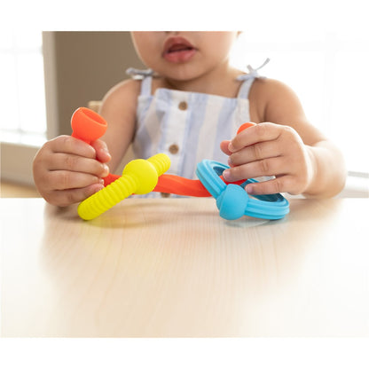Child playing with colorful plastic tools on a table