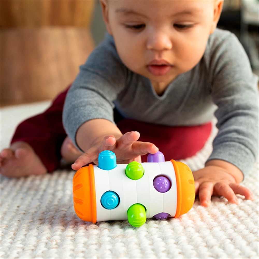 Baby playing with a colorful toy on a carpeted floor