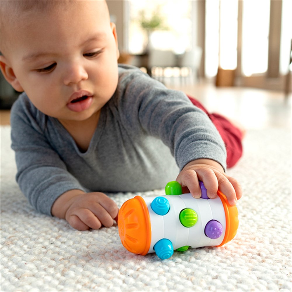 Child playing with a colorful toy on a carpeted floor