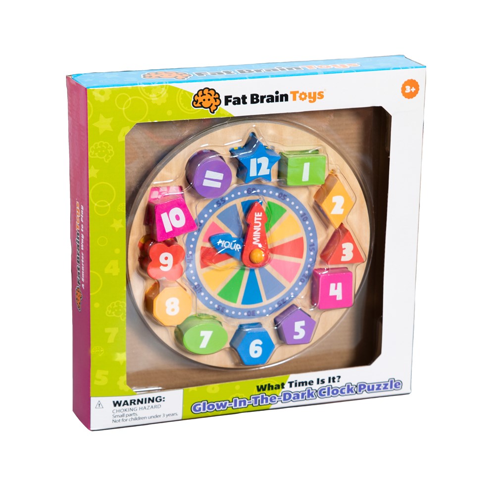 Fat Brain Toys 'What Time Is It?' Glow-In-The-Dark Clock Puzzle in its original retail packaging, featuring a colorful wooden puzzle with glowing numbers and a blue clock face.