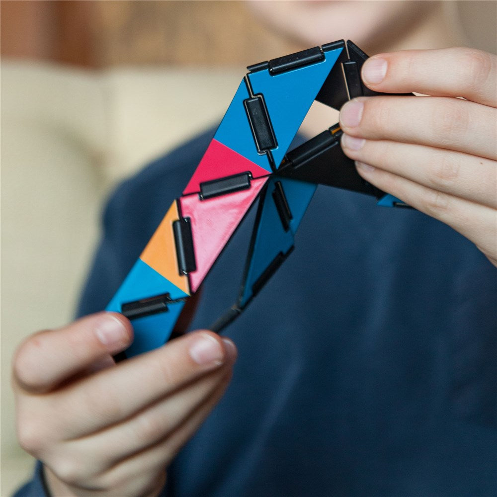 Person holding a colourful geometric puzzle with a blurred background