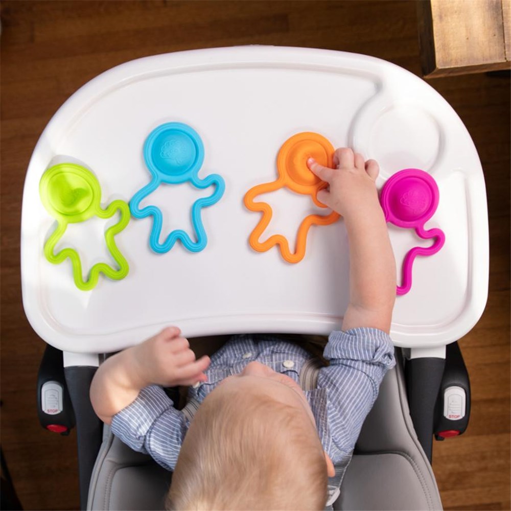 Child playing with colorful toys on a high chair tray