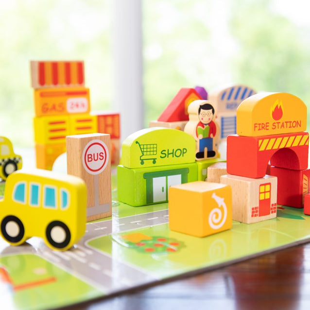 Colorful toy building blocks on a transparent base with a child's figure, resembling a cityscape.