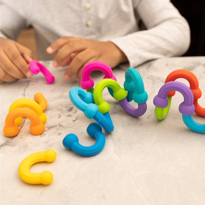 Child playing with colorful plastic toys on a table