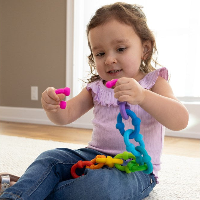 Child playing with colorful toys on a carpeted floor