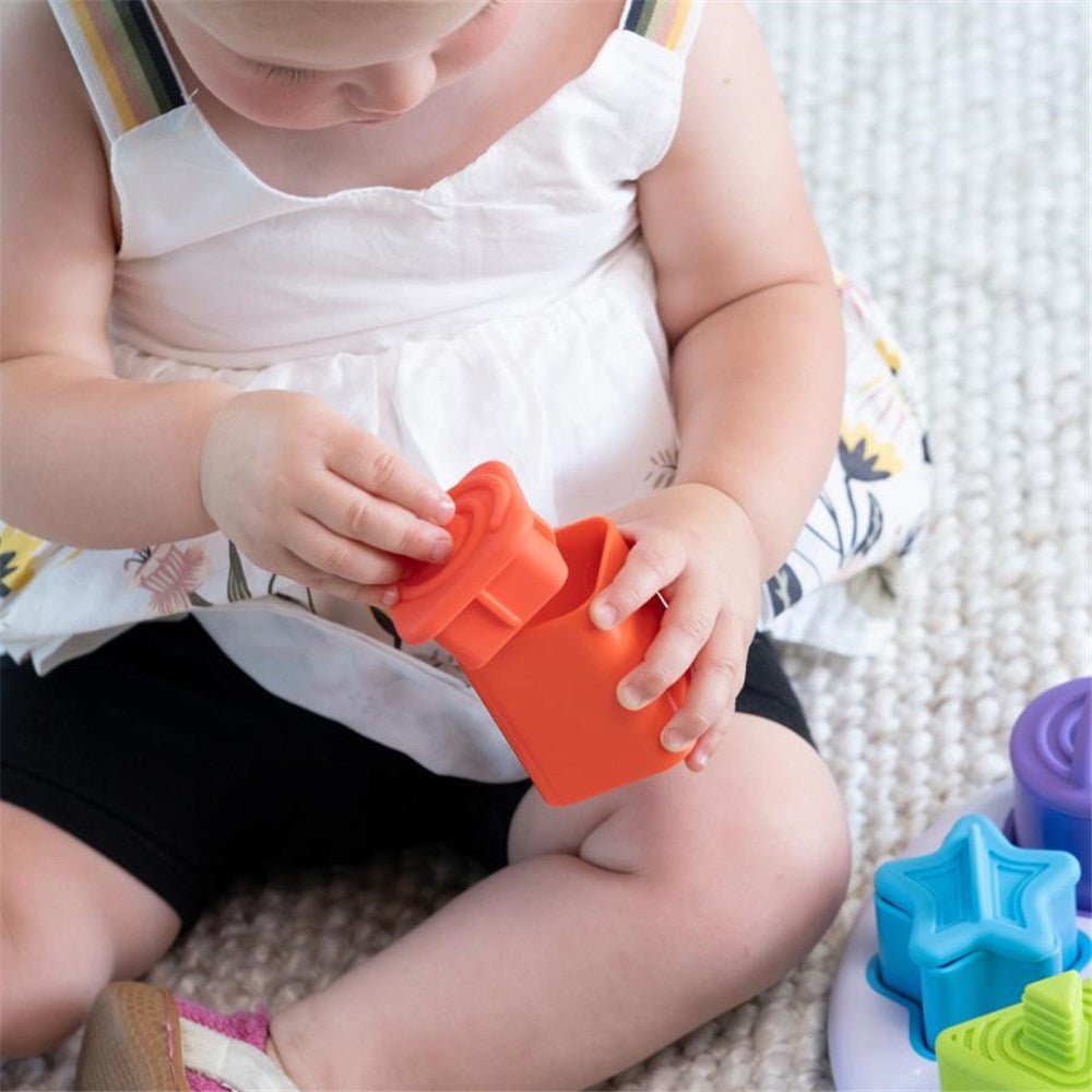 Child playing with colorful star-shaped toys on a carpeted floor