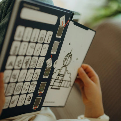 Person holding a book with a cartoon character on a wooden surface