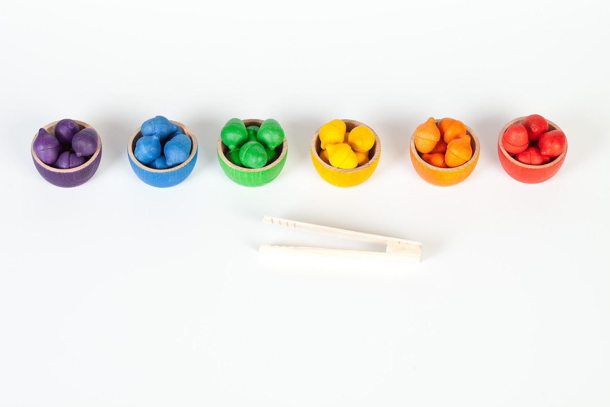 Set of colorful wooden xylophone-like instruments with mallet on a white background