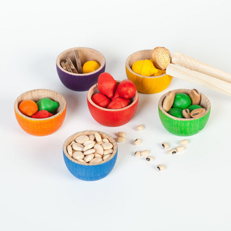 Colorful bowls with various objects on a white background