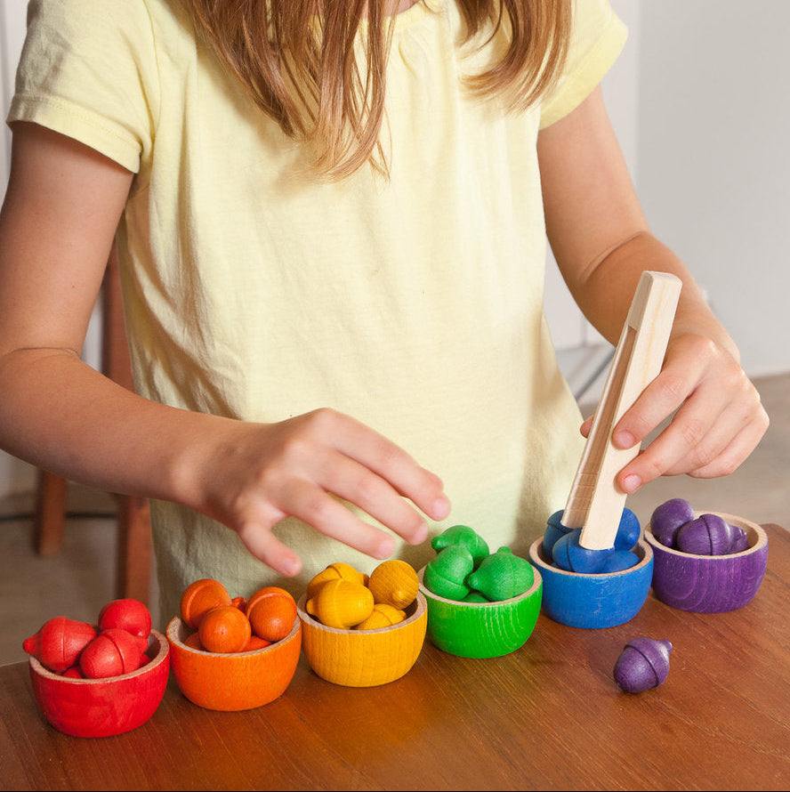 Child playing with colorful toys on a wooden table