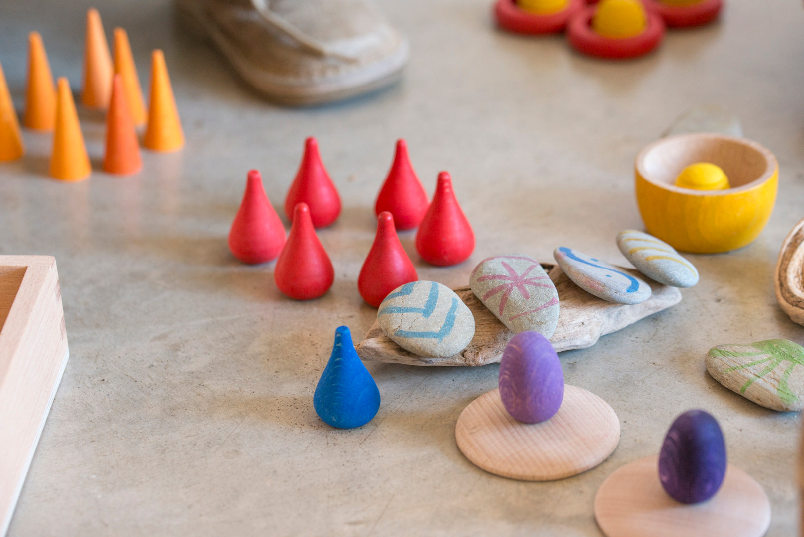 Colorful wooden and stone toys on a concrete surface