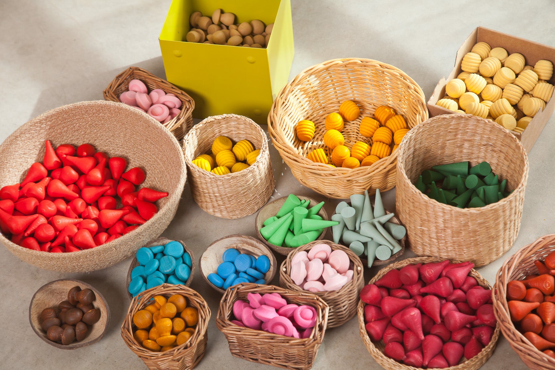 Colorful mandala pieces in woven baskets on a textured surface