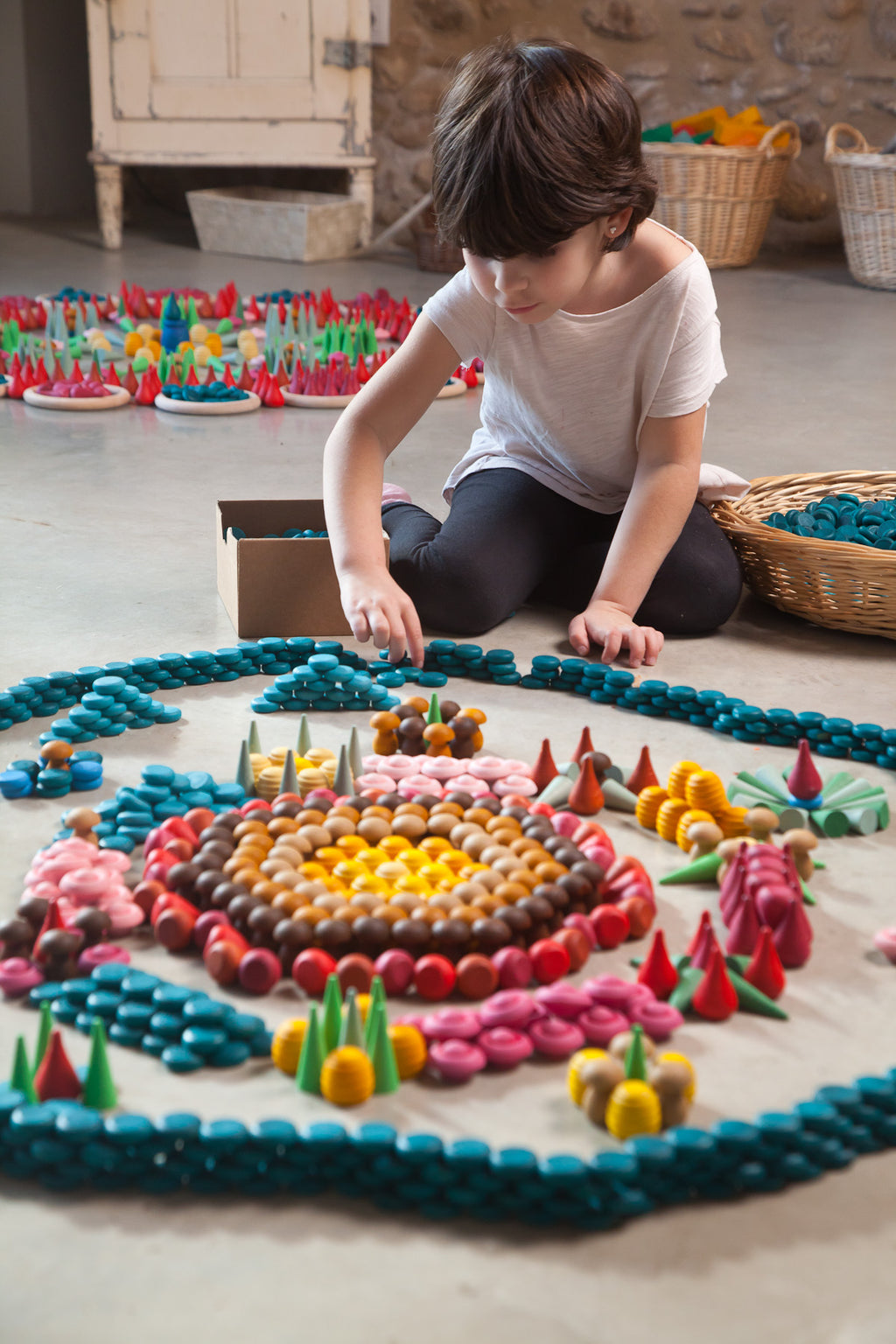 Child playing with colorful toys on a mat in a room.