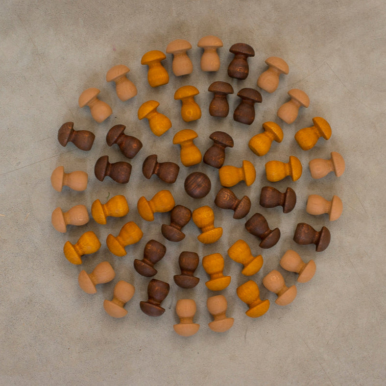 Collection of brown, orange, and beige buttons arranged in a circular pattern on a beige surface.