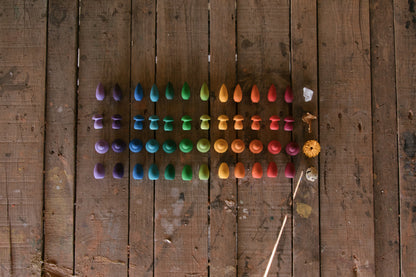 Colorful wooden buttons arranged in a pattern on a wooden surface