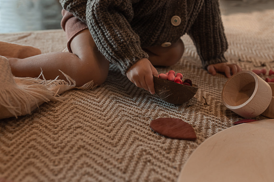 Child playing with wooden toys on a textured surface