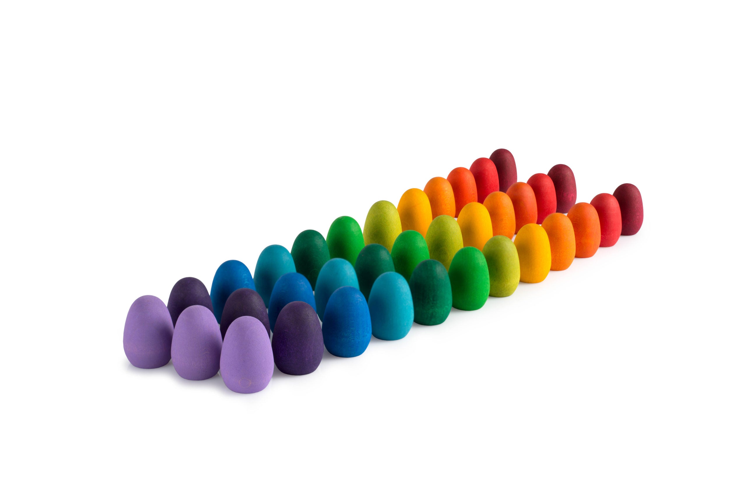 Row of colorful eggs in a rainbow pattern on a white background